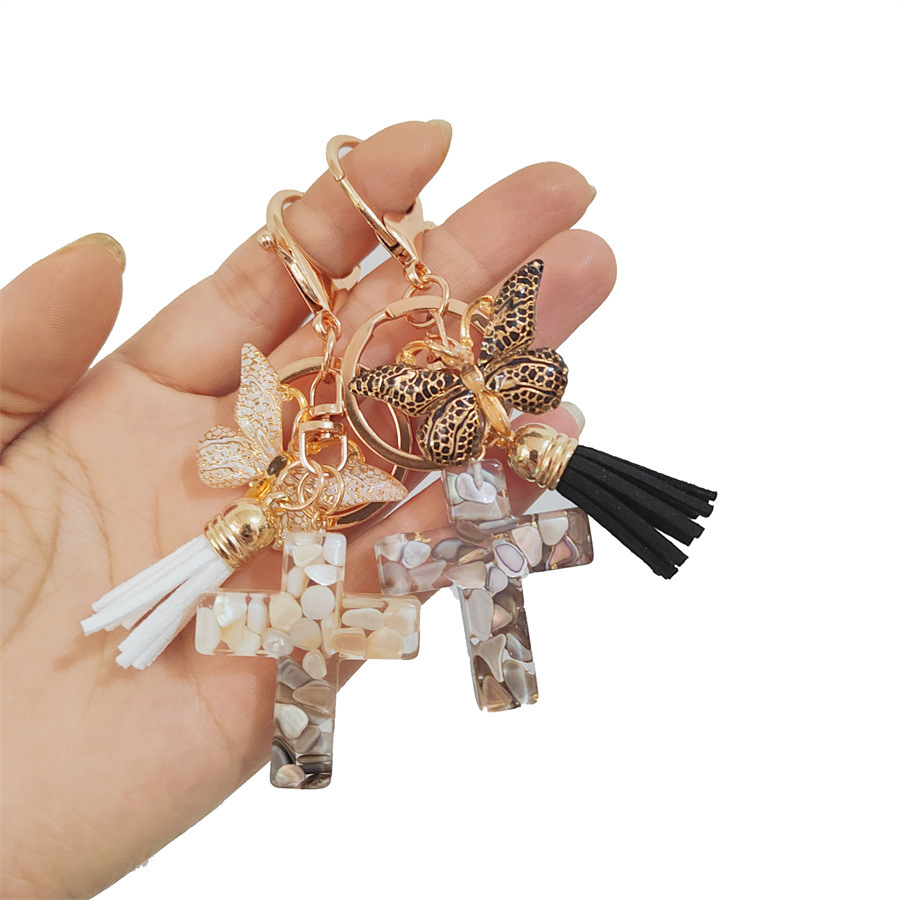 Breloque élégante en résine pailletée – Croix, papillon et pompon